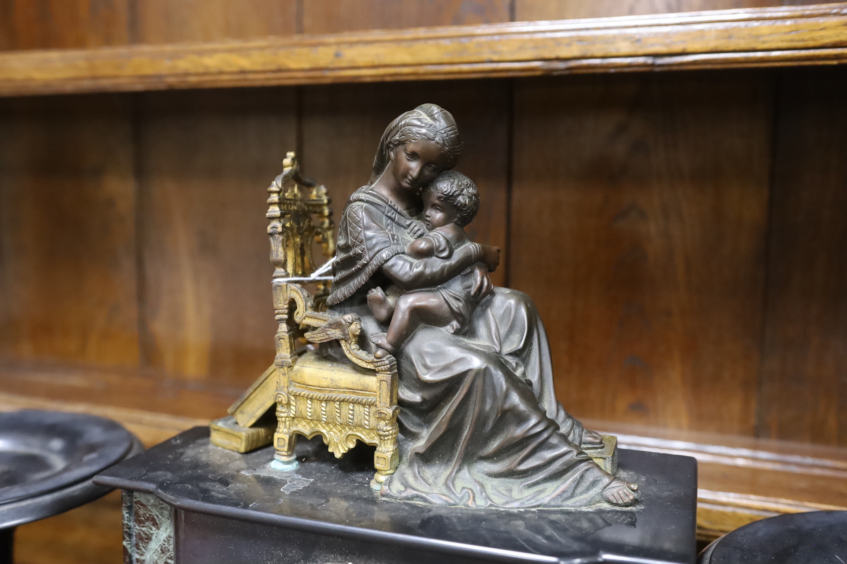 A late 19th century French black slate clock garniture with seated mother and child metal mount, clock 38cm high